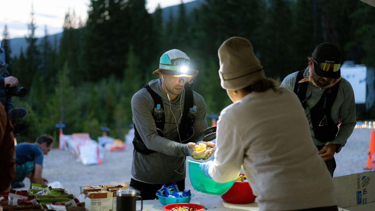 Gluten Free Carbohydrate Sources Man Wearing A Running Hat And Vest, Getting Orange Slices From A Race Station—and Excellent Source Of Gluten Free Carbohydrates.