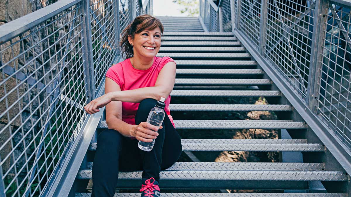 Image Of A Female Athlete Dealing With Menopause Taking A Break From Exercising With A Bottle Of Water