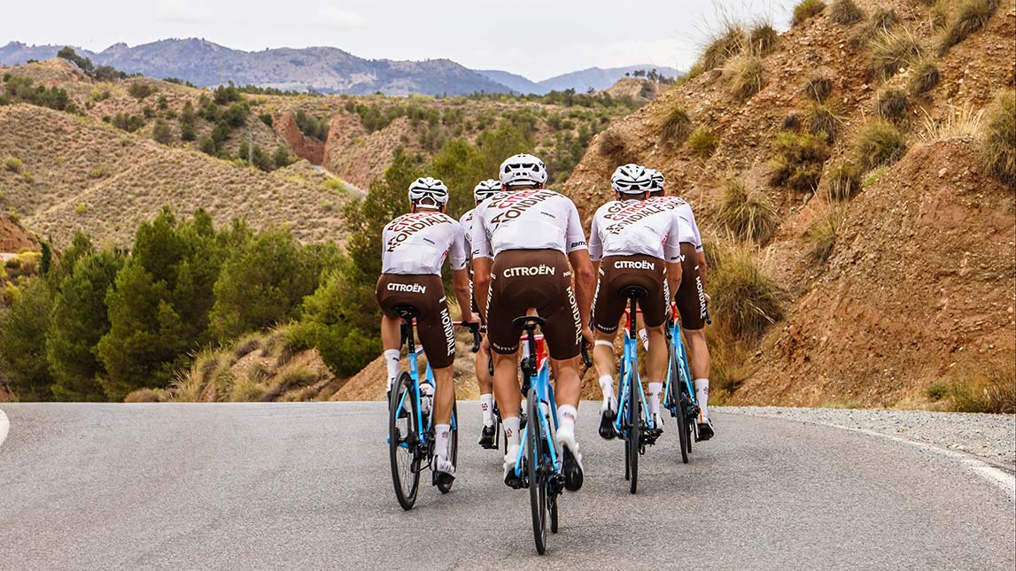 Team Of Professional Cyclists Riding Off Into The Distance