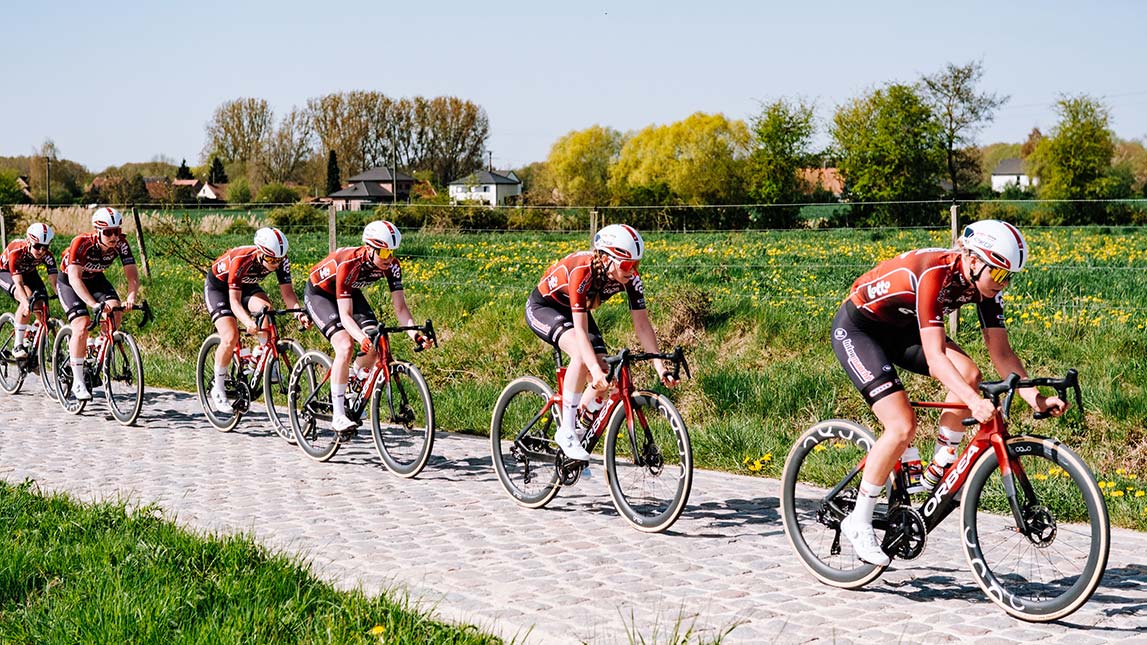 Professional Female Cyclists Riding Single File On Cobblestones Lotto Intermarche Ladies Team