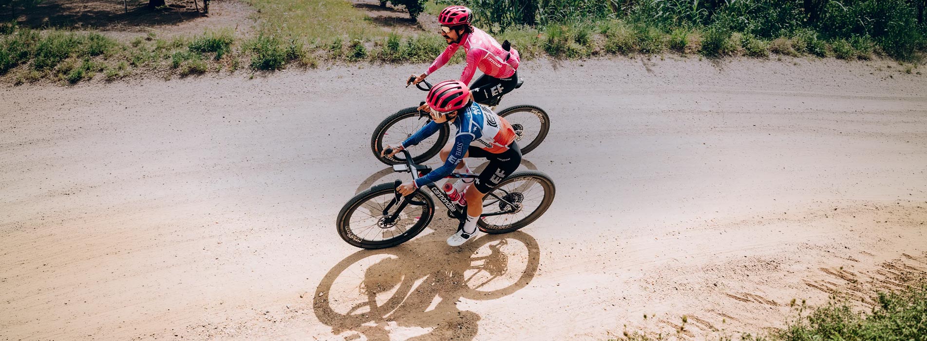 Trainingpeaks And Ef Education First Pro Cycling Male And Female Cyclists Riding Down Gravel Road Side By Side