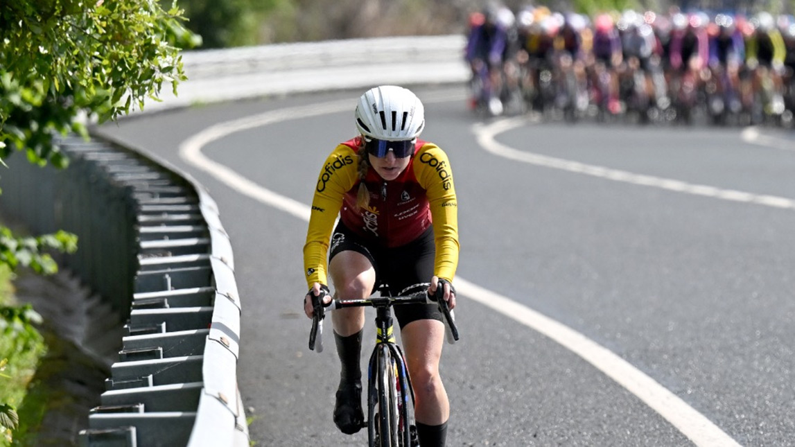 Trainingpeaks And Cofidis Female Cyclist From Team Cofidis Riding Off The Front Of The Peloton On Smooth Paved Road