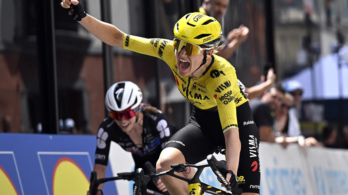 Trainingpeaks And Team Visma Lease A Bike Female Cyclist Crossing The Finish Line In First With Fist In The Air From Team Visma Lease A Bike