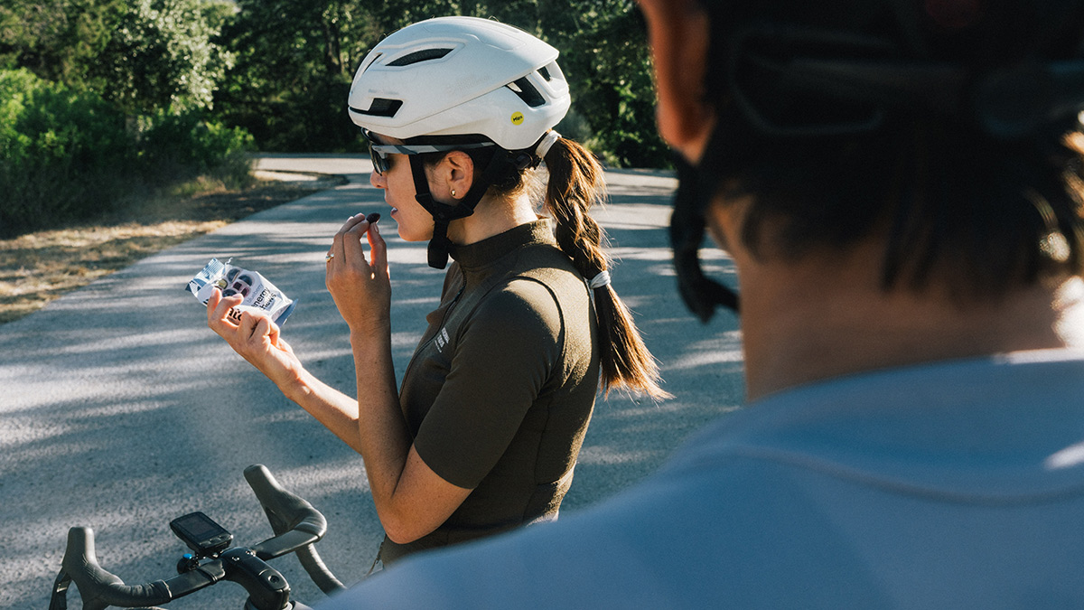 Female Cyclist Athlete On Bike Outside Fueling