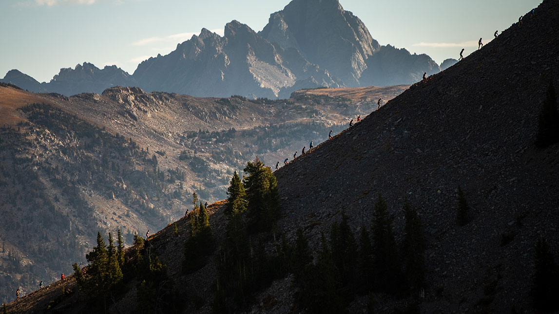 Cirque Series Athletes Running Up Snow Covered Mountain Ridge Cirque Series Athletes Running Up Rocky Mountain Side
