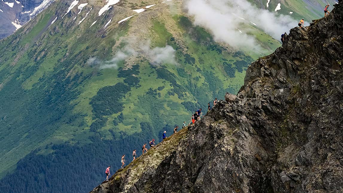 Cirque Series Athletes Running Up Snow Covered Mountain Ridge Cirque Series Athletes Running Up Rocky Mountain Side