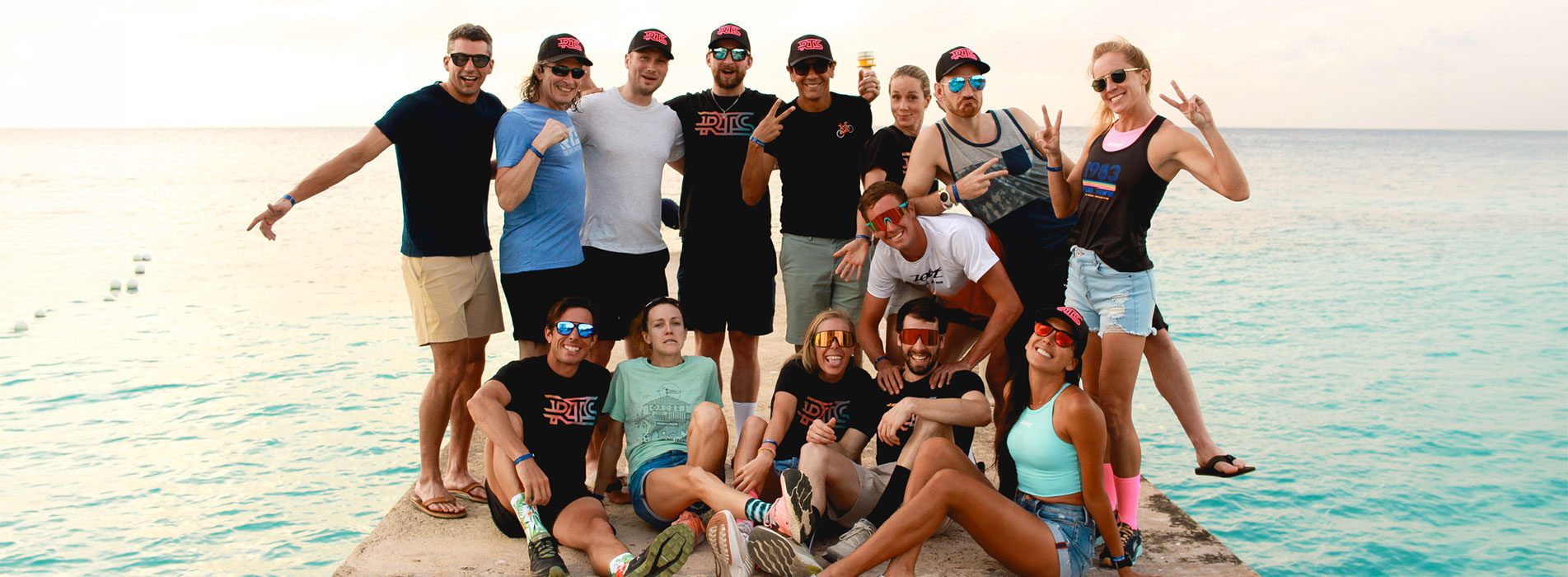 The Real Tri Squad Posing For Team Photo On Dock With Ocean In The Background
