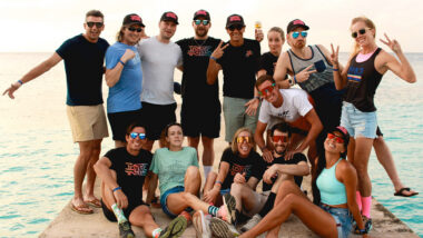 The Real Tri Squad posing for team photo on dock with ocean in the background
