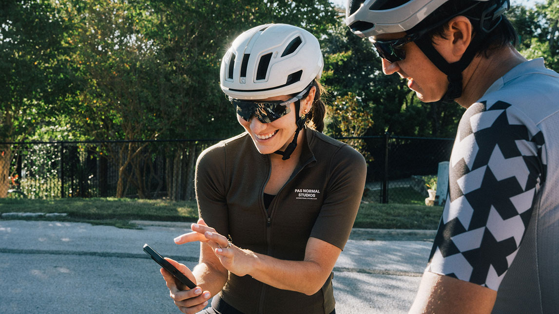 Female Cyclist Showing Her Phone To Her Coach
