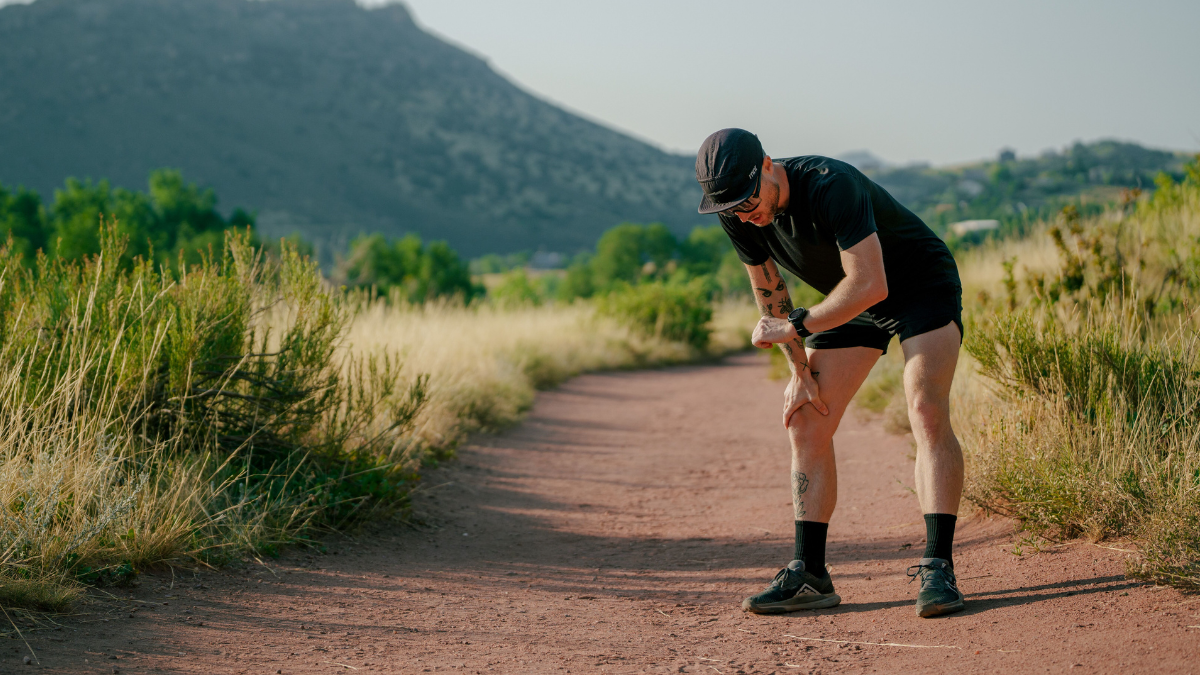 Adjusting Pace In The Heat Runner Man On Dirt Road Outside Checking Watch To Adjust Running In The Heat