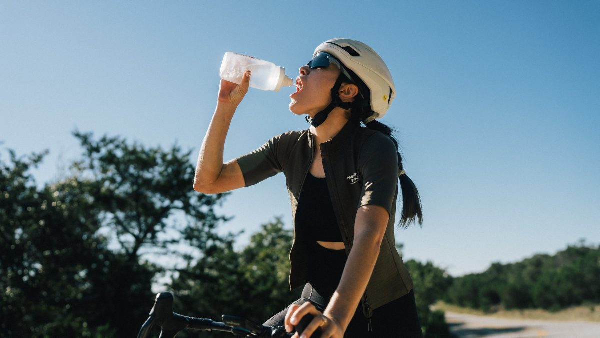 Hydration In The Heat Woman Taking A Break While Cycling In The Heat, Drinking Water To Maintain Optimal Hydration Levels.