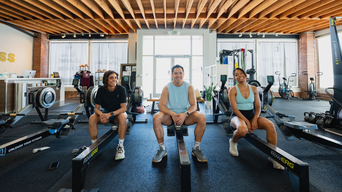 Hyrox Training Three Athletes Sitting In A Gym, Training For An Upcoming Hyrox Race.