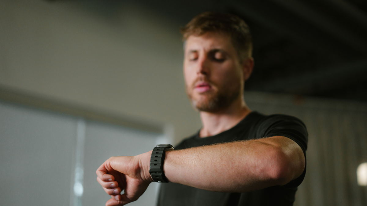 Male Athlete Wearing Black Shirt Using His Watch To Track Hrv As Part Of A Biofeedback Training Program.